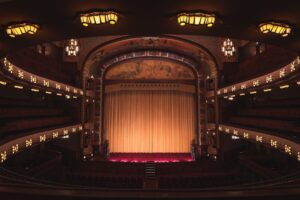 Lege historische schouwburg met verlicht podium en gesloten gordijn