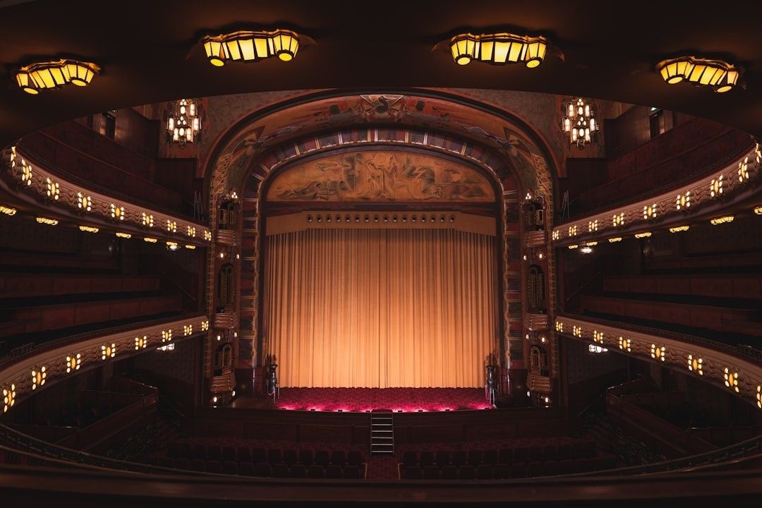 Lege historische schouwburg met verlicht podium en gesloten gordijn